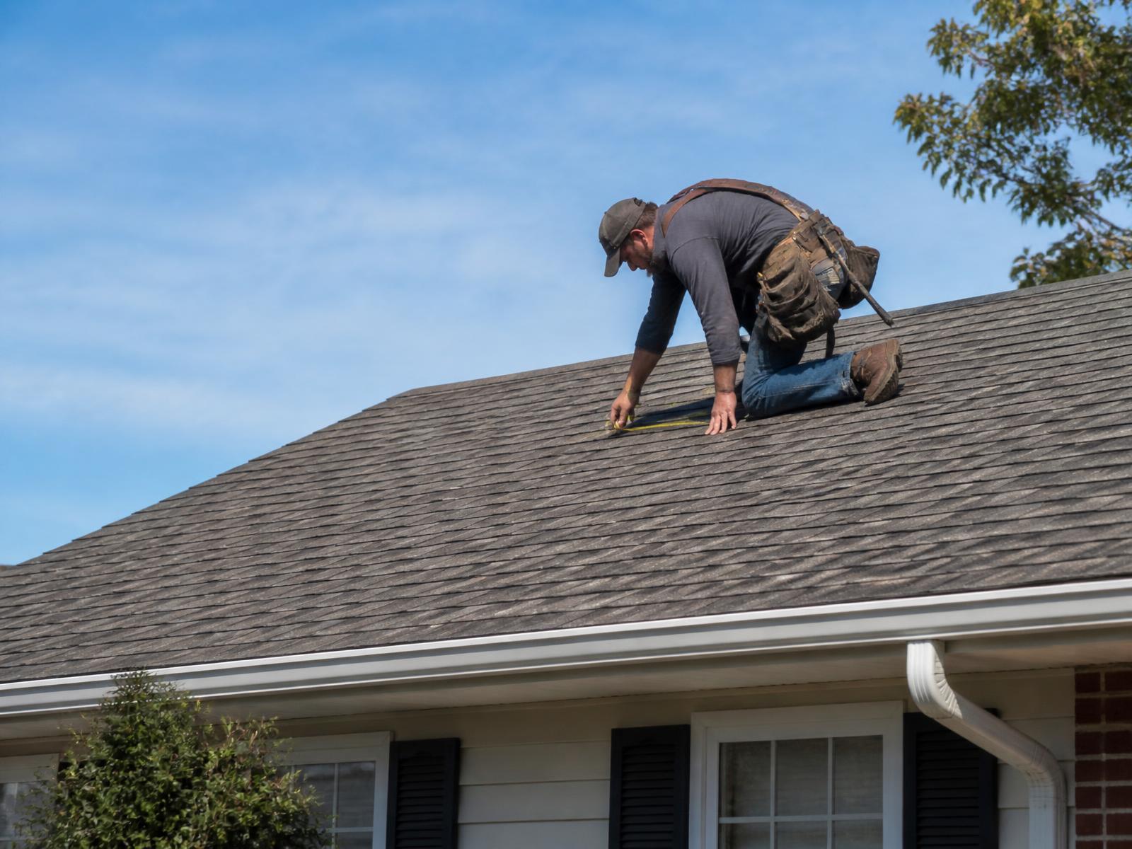 A roofing professional inspecting a home's roof